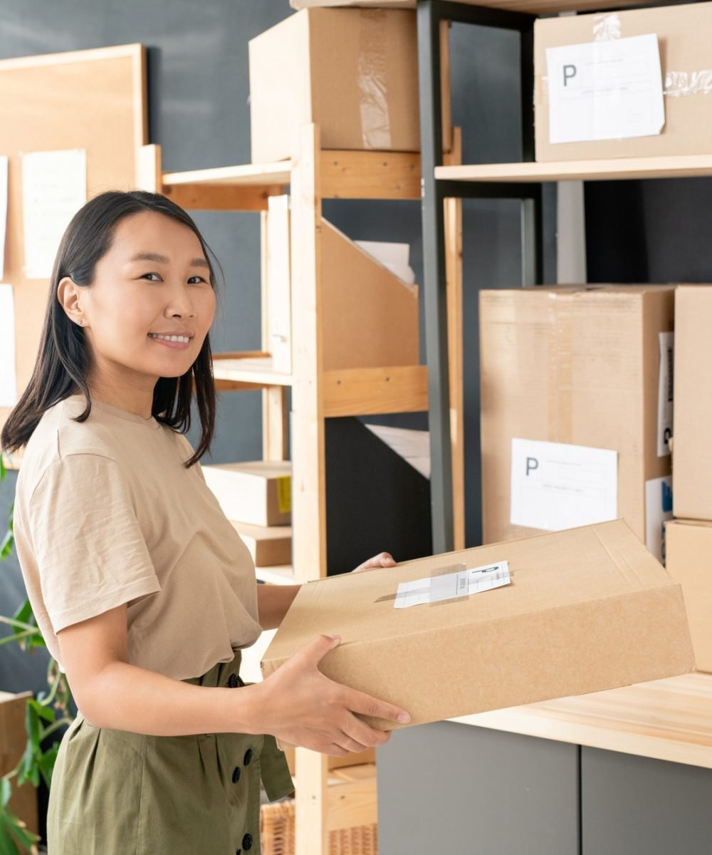 smiling-youngworker-of-post-office-or-storage-room-carrying-order-of-client.jpg